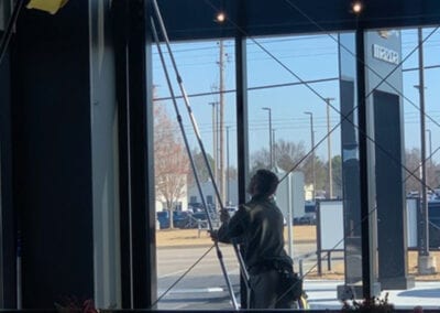 Person cleaning the glass walls of the commercial building